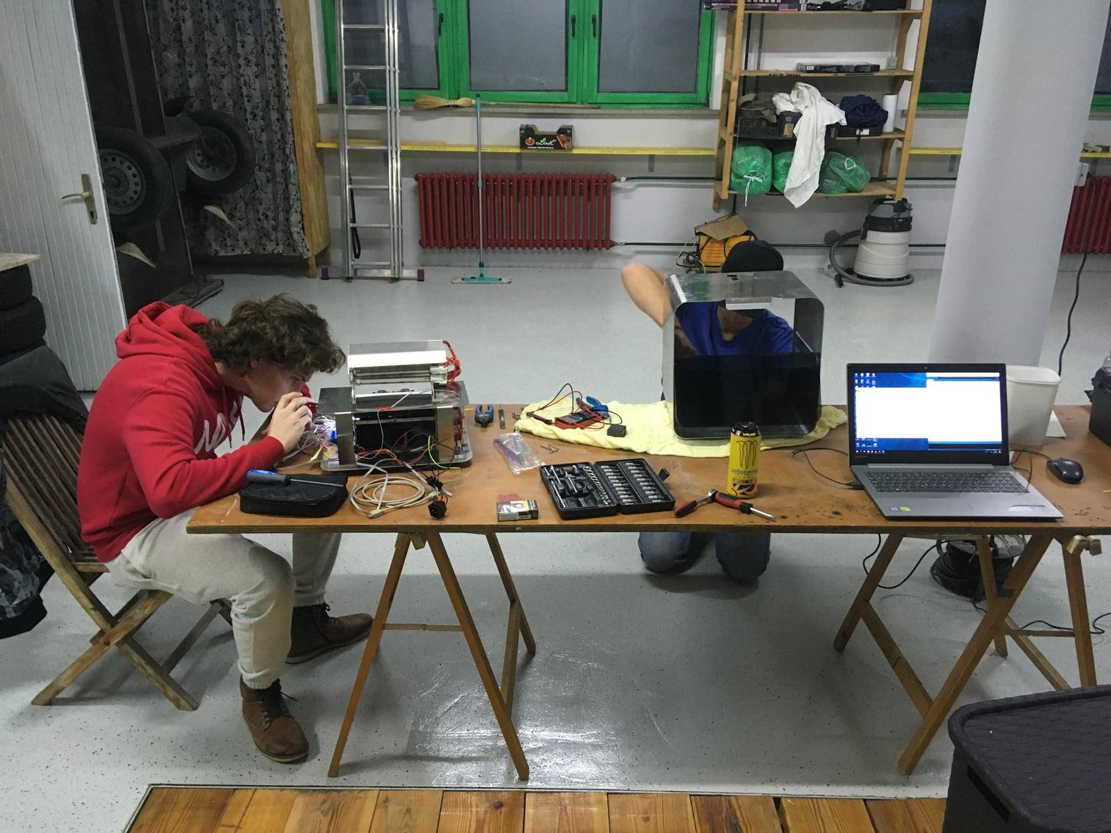 Engineer assembling Cash Cleaner electronics at a workshop table