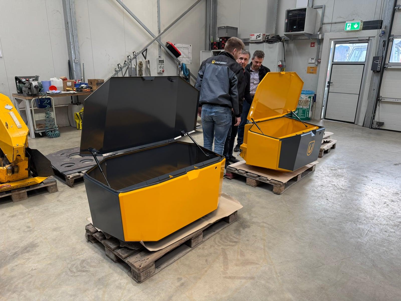 Team reviewing two Unibox prototypes in the workshop