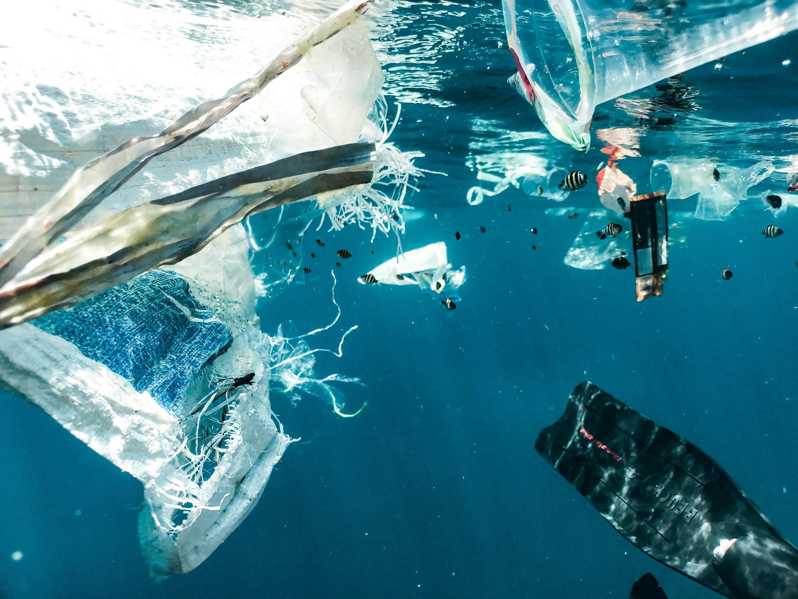 Plastic bags and bottles floating underwater in the ocean