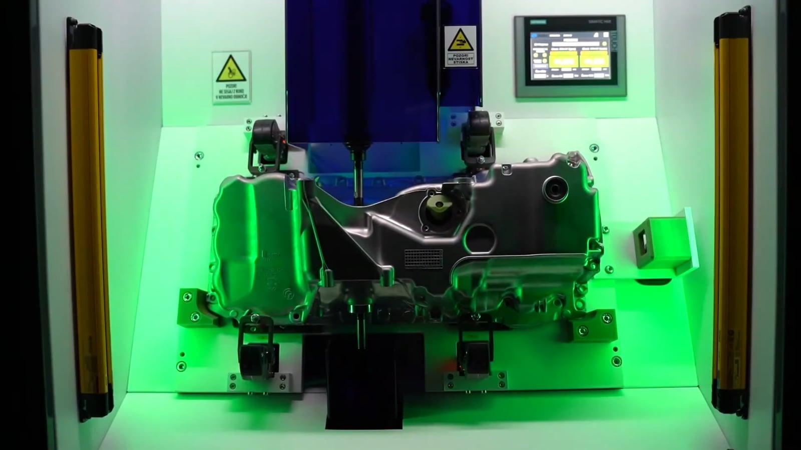 Measurement booth working area lit green with a workpiece clamped in the fixture, signalling a pass