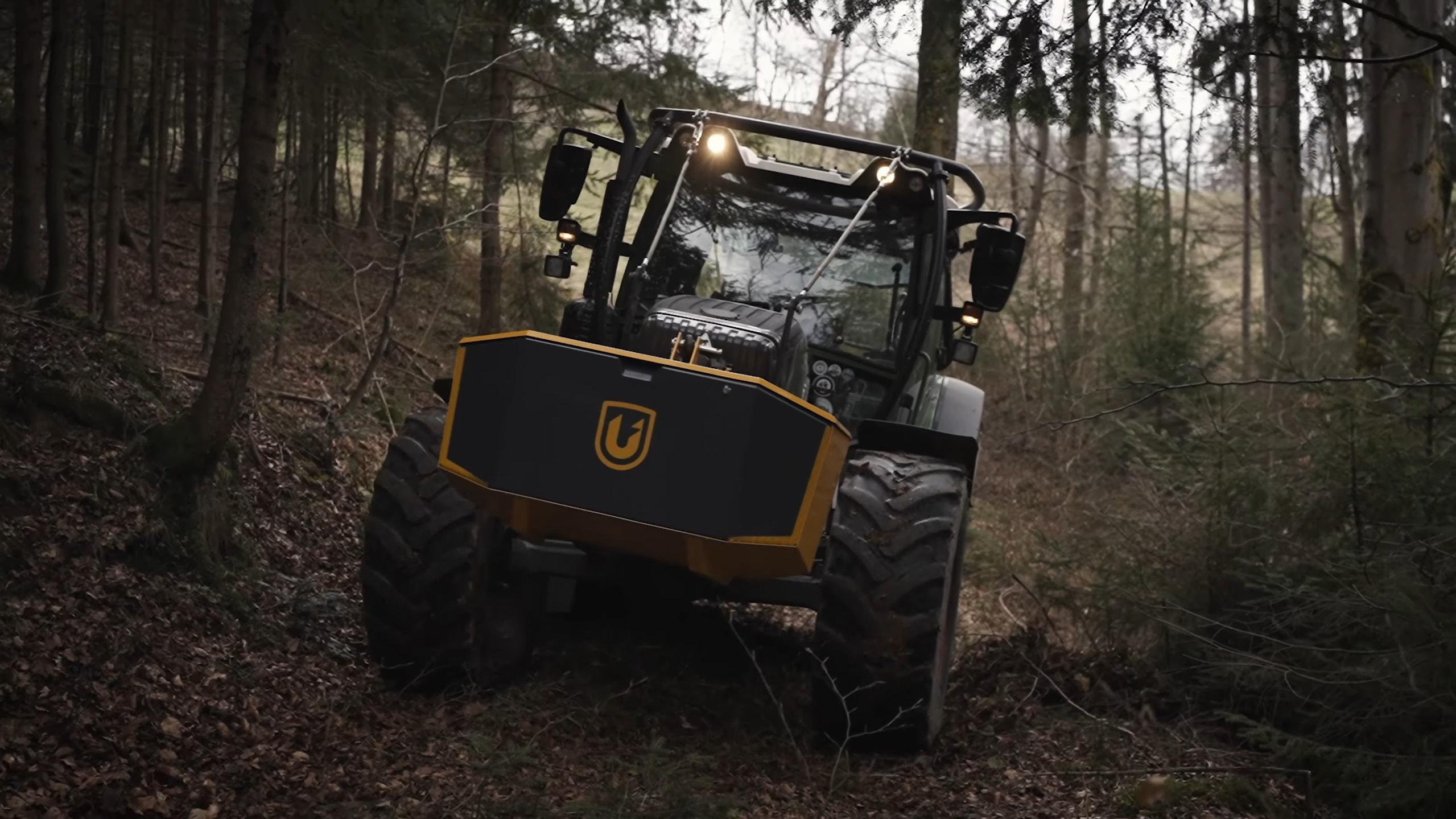 Tractor with Unibox climbing through a dark forest